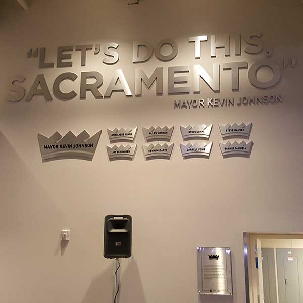 Dimensional wall lettering reading Let's Do This, Sacramento with crown-shaped name plaques installed on an interior wall