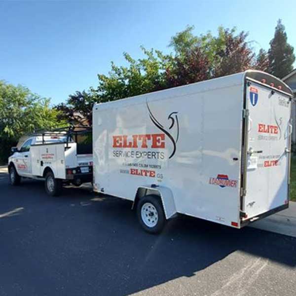 Elite Service Experts branded box trailer and service truck with printed vehicle graphics